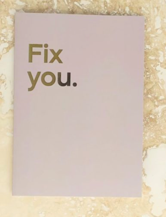 "Fix you" in metallic foiling on a beige background